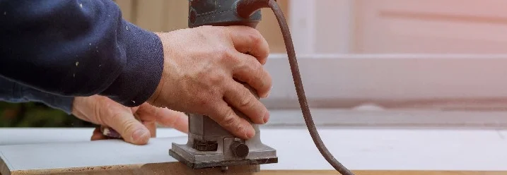 Person fräst Holz mit Oberfräse